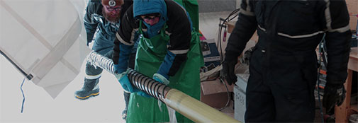 Drillers Dennis Wistisen (left) and Bruce Vaughn (middle) extract the inner core barrel. Seconds later, chief driller Trevor Popp (right) disconnects the inner core barrel from the drill, so the core barrel which holds the freshly drilled ice core can be moved to the logging table. The chips are separated from the drill liquid, which is recycled. 