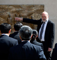 John Renner Hansen viser bronzerelief frem for delegationen