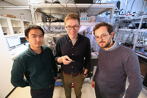 PhD studerende Junxin Chen and Massimiliano Rossi står på hver side af David Mason, førsteforfatter på artiklen i Nature Physics.