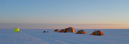 Evening view over camp. “The Press Office” to the left, and to the right the main tent with two personal tents on each side. Evening view over camp